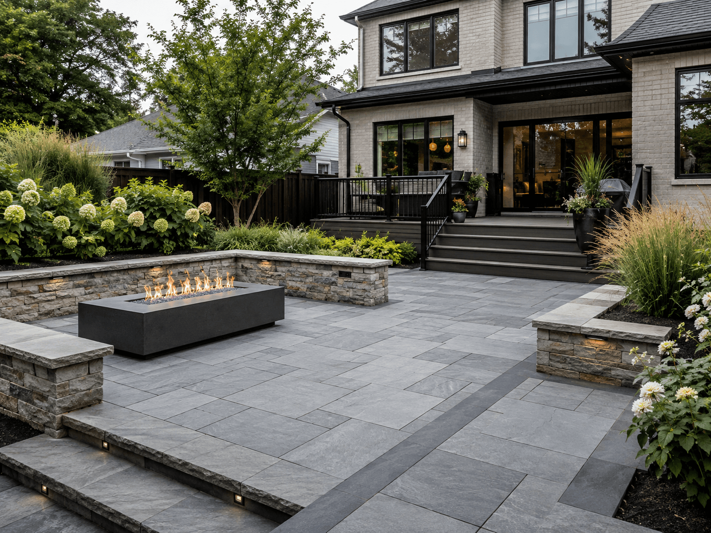 Premium paver patio with stone seating wall and fire feature in Oakville by McCoy Landscape Group